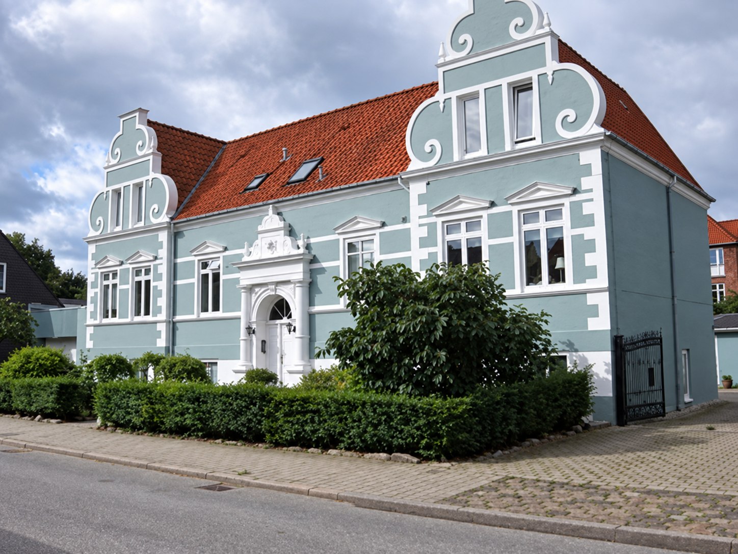 Lyseblå ejendom med hvide detaljer